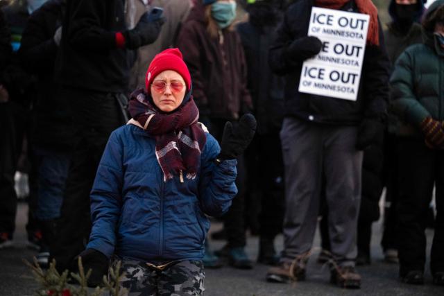 A woman prays at a makeshift memorial in the area where 37-year-old Alex Pretti was shot dead by federal immigration agents earlier in the day in Minneapolis, Minnesota, on January 24, 2026. Federal immigration agents shot dead a man in Minneapolis on Saturday, in the second fatal shooting of a civilian during the Trump administration's unprecedented operation in the city, sparking fresh protests and outrage from state officials. The death came less than three weeks after US citizen Renee Good was shot and killed by an ICE officer. (Photo by ROBERTO SCHMIDT / AFP)