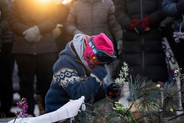 A woman prays at a makeshift memorial in the area where 37-year-old Alex Pretti was shot dead by federal immigration agents earlier in the day in Minneapolis, Minnesota, on January 24, 2026. Federal immigration agents shot dead a man in Minneapolis on Saturday, in the second fatal shooting of a civilian during the Trump administration's unprecedented operation in the city, sparking fresh protests and outrage from state officials. The death came less than three weeks after US citizen Renee Good was shot and killed by an ICE officer. (Photo by ROBERTO SCHMIDT / AFP)