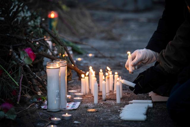 People light candles at a makeshift memorial in the area where 37-year-old Alex Pretti was shot dead by federal immigration agents earlier in the day in Minneapolis, Minnesota, on January 24, 2026. Federal immigration agents shot dead a man in Minneapolis on Saturday, in the second fatal shooting of a civilian during the Trump administration's unprecedented operation in the city, sparking fresh protests and outrage from state officials. The death came less than three weeks after US citizen Renee Good was shot and killed by an ICE officer. (Photo by ROBERTO SCHMIDT / AFP)
