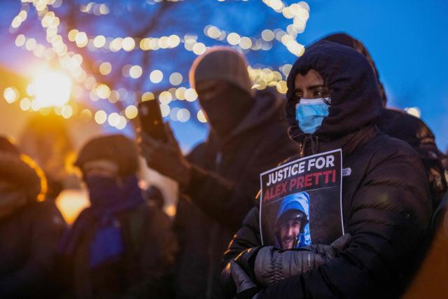 People mourn at a makeshift memorial in the area where 37-year-old Alex Pretti was shot dead by federal immigration agents earlier in the day in Minneapolis, Minnesota, on January 24, 2026. Federal immigration agents shot dead a man in Minneapolis on Saturday, in the second fatal shooting of a civilian during the Trump administration's unprecedented operation in the city, sparking fresh protests and outrage from state officials. The death came less than three weeks after US citizen Renee Good was shot and killed by an ICE officer. (Photo by ROBERTO SCHMIDT / AFP)