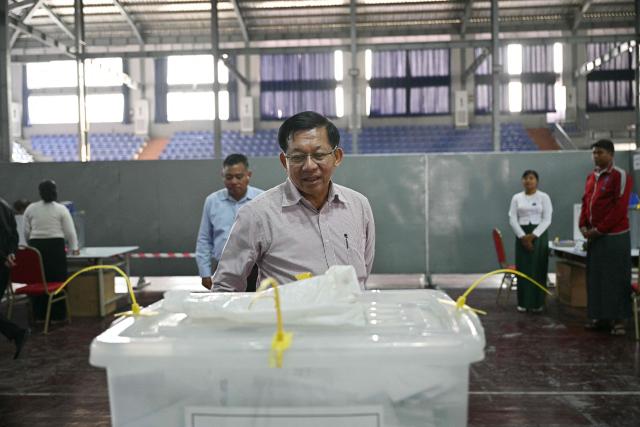 Myanmar's military chief Min Aung Hlaing (C) looks at a sealed ballot box with advance votes during his visit to a polling station on the third and final phase of Myanmar's general election in Mandalay on January 25, 2026. Myanmar opened the final round of its month-long election on January 25, with the dominant pro-military party on course for a landslide in a junta-run vote critics say will prolong the army's grip on power. (Photo by ANTHONY WALLACE / AFP)