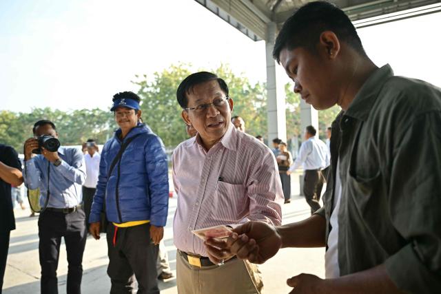 Myanmar's military chief Min Aung Hlaing (2nd R) speaks to a voter during his visit to a polling station on the third and final phase of Myanmar's general election in Mandalay on January 25, 2026. Myanmar opened the final round of its month-long election on January 25, with the dominant pro-military party on course for a landslide in a junta-run vote critics say will prolong the army's grip on power. (Photo by ANTHONY WALLACE / AFP)