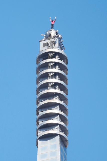 US rock climber Alex Honnold raises his arms from the top of the Taipei 101 building after he successfully free soloed the landmark skyscraper without ropes or safety gear in Taipei on January 25, 2026. (Photo by I-HWA CHENG / AFP)