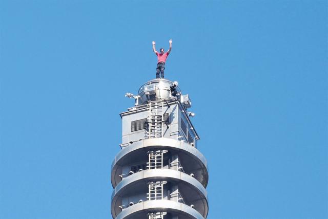 TOPSHOT - US rock climber Alex Honnold raises his arms from the top of the Taipei 101 building after he successfully free soloed the landmark skyscraper without ropes or safety gear in Taipei on January 25, 2026. (Photo by I-HWA CHENG / AFP)