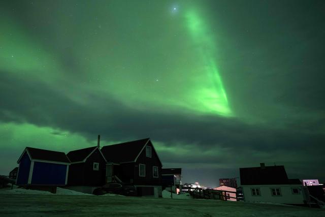 Northern Lights (Aurora Borealis) glow above the city of Nuuk during a power outage on January 25, 2026, in Greenland. (Photo by Jonathan NACKSTRAND / AFP)