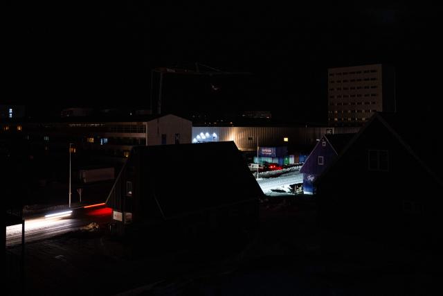 A road in downtown Nuuk is illuminated by car beams during a power outage on January 24, 2026, in Greenland. (Photo by Jonathan NACKSTRAND / AFP)