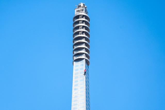 US rock climber Alex Honnold closes in to the top of the Taipei 101 building as he free soloes the landmark skyscraper without ropes or safety gear in Taipei on January 25, 2026. (Photo by I-Hwa Cheng / AFP)