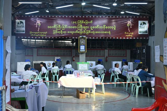 Election volunteers wait for voters at a polling station during the third and final phase of Myanmar's general election in Yangon on January 25, 2026. Myanmar opened the final round of its month-long election on January 25, with the dominant pro-military party on course for a landslide in a junta-run vote critics say will prolong the army's grip on power. (Photo by Sai Aung MAIN / AFP)