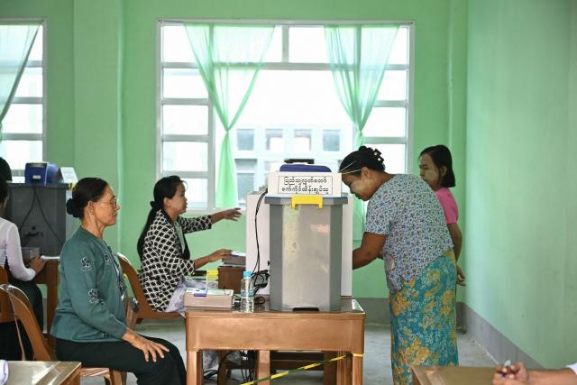 People cast their vote inside a polling station during the third and final phase of Myanmar's general election in Yangon on January 25, 2026. Myanmar opened the final round of its month-long election on January 25, with the dominant pro-military party on course for a landslide in a junta-run vote critics say will prolong the army's grip on power. (Photo by Sai Aung MAIN / AFP)
