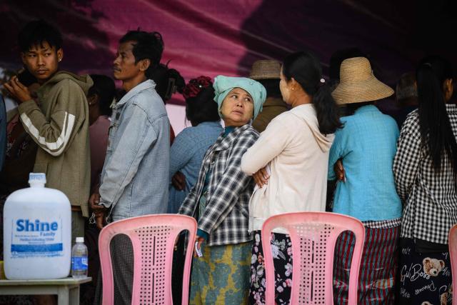 People line up to check a voter list before casting their ballots at a polling station during the third and final phase of Myanmar's general election in Mandalay on January 25, 2026. Myanmar opened the final round of its month-long election on January 25, with the dominant pro-military party on course for a landslide in a junta-run vote critics say will prolong the army's grip on power. (Photo by ANTHONY WALLACE / AFP)