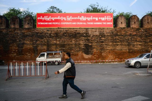 A man walks past the Mandalay Palace in Mandalay on January 25, 2026. (Photo by ANTHONY WALLACE / AFP)