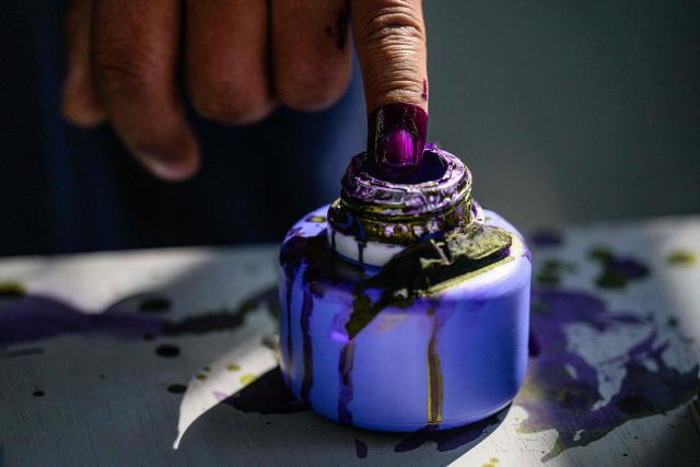 A voter inks their finger after casting their ballot at a polling station during the third and final phase of Myanmar's general election in Mandalay on January 25, 2026. Myanmar opened the final round of its month-long election on January 25, with the dominant pro-military party on course for a landslide in a junta-run vote critics say will prolong the army's grip on power. (Photo by ANTHONY WALLACE / AFP)
