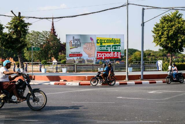 Motorists drive past a billboard that translates as “From the election to a better future” in Mandalay on January 25, 2026, as Myanmar votes in the third and final phase of the country’s general election. (Photo by ANTHONY WALLACE / AFP)