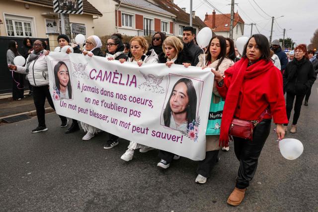 Relatives, friends and mourners hold a baner reading "Camelia, forever in our hearts - we will not forget you - a word can hurt, a word can save" as they walk during a silent march for 17-year-old girl Camelia, a high school student who committed suicide at Mitry-Mory station following school harassment, in Mitry-Mory on January 25, 2026. The family of 17-year-old high school student Camelia, who committed suicide in Mitry-Mory (Seine-et-Marne), has filed a complaint and will soon be heard as part of the investigations opened after the teenager's death, the Meaux public prosecutor said. On January 14, 2026 the day after the teenager's death, two investigations were opened, one of which was for ‘bullying at school leading to the victim's suicide’. (Photo by Thomas SAMSON / AFP)