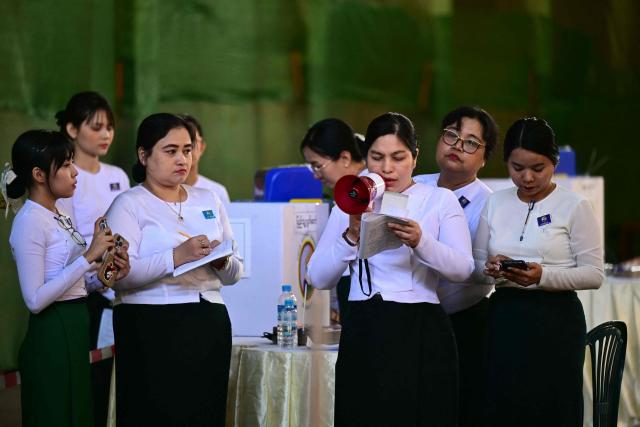 Members of Myanmar’s Union Election commission (UEC) count ballots after the closing of polls at a polling station in the third phase of Myanmar’s general election in Yangon on January 25, 2026. (Photo by Sai Aung MAIN / AFP)