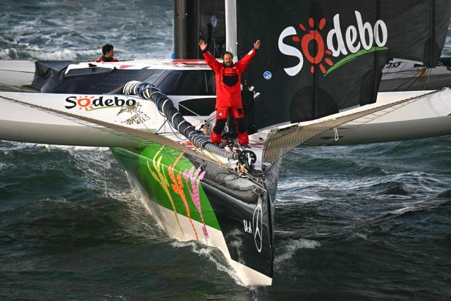 French skipper Thomas Coville celebrates aboard the Ultim class multihull "Sodebo Ultim 3" as he arrives with his crew at the end of their Jules Verne Trophy attempt, in the Atlantic Ocean, off the coast of Brest, Brittany, western France, on January 25, 2026. Thomas Coville (Sodebo) and his six crew members completed a non-stop round-the-world voyage off the coast of Brest on January 25, 2026 in a record time of 40 days, 10 hours and 45 minutes, beating the previous Jules Verne Trophy record by 12 hours, his team announced. The Jules Verne Trophy is a prize for the fastest crewed, unassisted and non-stop circumnavigation of the world on any type of yacht. (Photo by LOIC VENANCE / AFP)