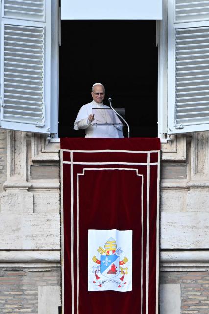 Pope Leo XIV looks at the crowd from the window of the apostolic palace overlooking St. Peter's square during the Angelus prayer in the Vatican on January 25, 2026. (Photo by Andreas SOLARO / AFP)