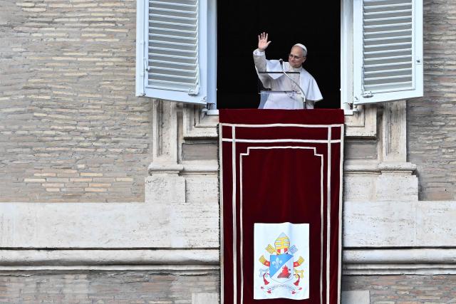 Pope Leo XIV waves to the crowd from the window of the apostolic palace overlooking St. Peter's square during the Angelus prayer in the Vatican on January 25, 2026. (Photo by Andreas SOLARO / AFP)