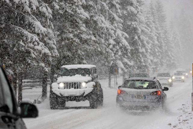 Motorists travel in heavy snow fall along a mountain pass road near Toblach running between the Olympic venues in Cortina and Antholz, northern Italy prior to the Milano Cortina 2026 Olympic Games, on January 25, 2026. (Photo by Odd ANDERSEN / AFP)