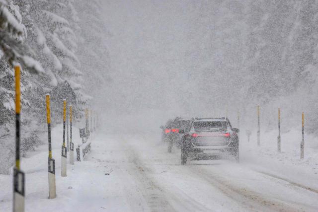 Motorists travel in heavy snow fall along a mountain pass road near Toblach running between the Olympic venues in Cortina and Antholz, northern Italy prior to the Milano Cortina 2026 Olympic Games, on January 25, 2026. (Photo by Odd ANDERSEN / AFP)