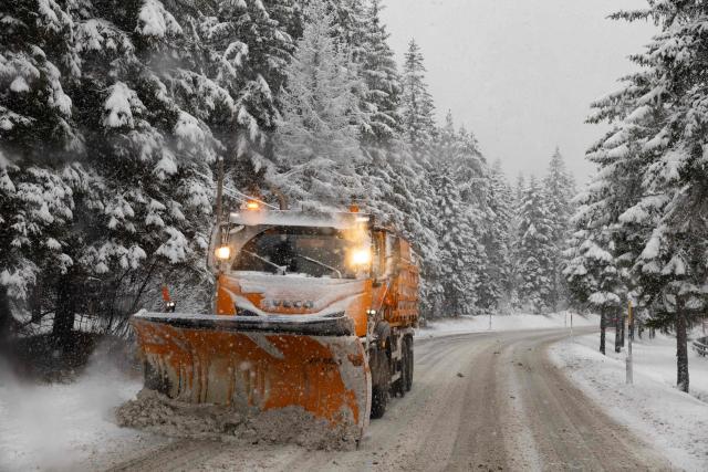 A plow clears snow along a mountain pass road near Toblach running between the Olympic venues in Cortina and Antholz, northern Italy prior to the Milano Cortina 2026 Olympic Games, on January 25, 2026. (Photo by Odd ANDERSEN / AFP)