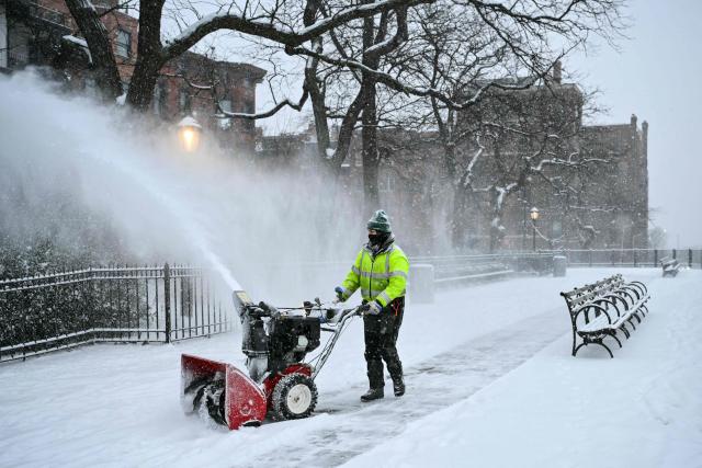 A worker clears snow from the Brooklyn Heights Promenade in New York City on January 25, 2026. A massive winter storm on January 24 dumped snow and freezing rain from New Mexico to North Carolina as it swept across the United States towards the northeast, threatening tens of millions of Americans with blackouts, transportation chaos and bone-chilling cold. After battering the country's southwest and central areas, the storm system began to hit the heavily populated mid-Atlantic and northeastern states as a frigid air mass settled in across the nation. (Photo by ANGELA WEISS / AFP)