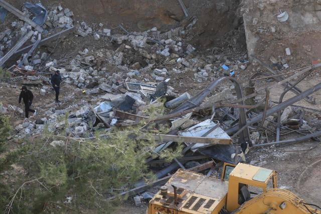 Lebanese inspect the scence following an Israeli airstrike that targeted a building in the southern Lebanese village of Kfar Dounine on January 25, 2026. An Israeli strike on south Lebanon killed one person on Janauary 25, the health ministry reported, as Israel's military said it struck Hezbollah targets. More than 350 people have been killed by Israeli fire in Lebanon despite the November 2024 truce, according to an AFP tally of health ministry reports. (Photo by Mahmoud ZAYYAT / AFP)