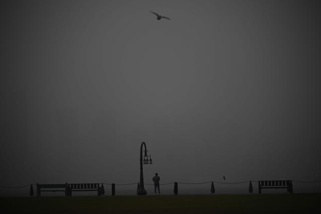 A man stands at the beach during a dust storm in Qatar's capital Doha, on January 25, 2026. (Photo by Mahmud HAMS / AFP)