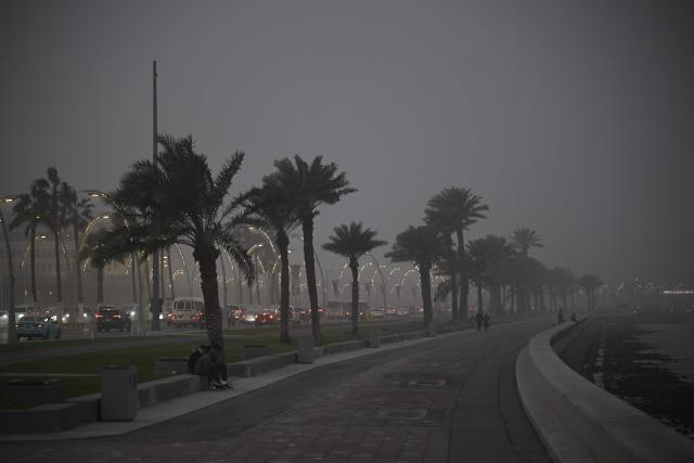 Vehicles drive during a dust storm in Qatar's capital Doha, on January 25, 2026. (Photo by Mahmud HAMS / AFP)