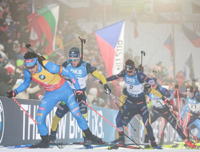 Italy's Tommaso Giacomel (L) competes in the men's 15 km mass start competition of the IBU Biathlon World Cup in Nove Mesto, Czech Republic, on January 25,  2026. (Photo by Radek MICA / AFP)