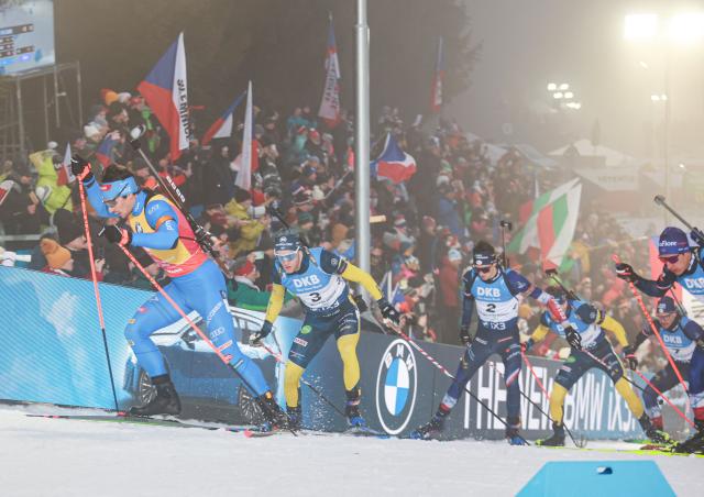 Italy's Tommaso Giacomel (L) competes in the men's 15 km mass start competition of the IBU Biathlon World Cup in Nove Mesto, Czech Republic, on January 25,  2026. (Photo by Radek MICA / AFP)