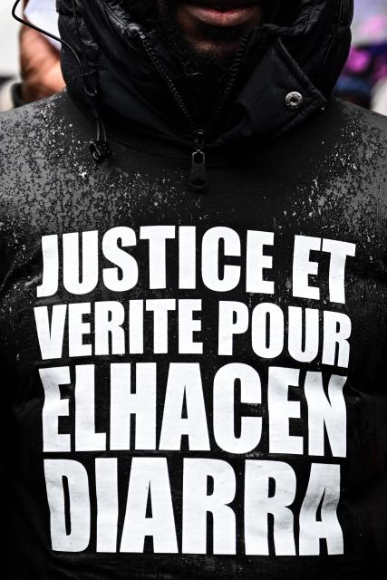 A participant wearing a t-shirt reading "Justice and truth for  El Hacen Diarra" takes part in a march in tribute to 35-year-old El Hacen Diarra, who died in police custody at the police station of Paris's 20th arrondissement, in Paris on January 25, 2026. (Photo by Blanca CRUZ / AFP)