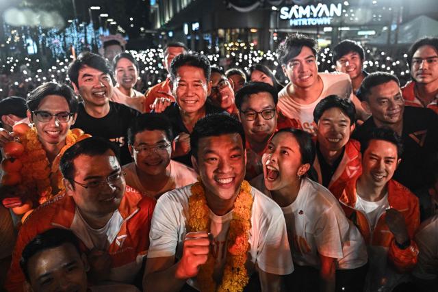People's Party leader and prime ministerial candidate Natthaphong Ruengpanyawut poses on stage with fellow party members at a rally ahead of the general election in Bangkok on January 25, 2026. (Photo by Lillian SUWANRUMPHA / AFP)