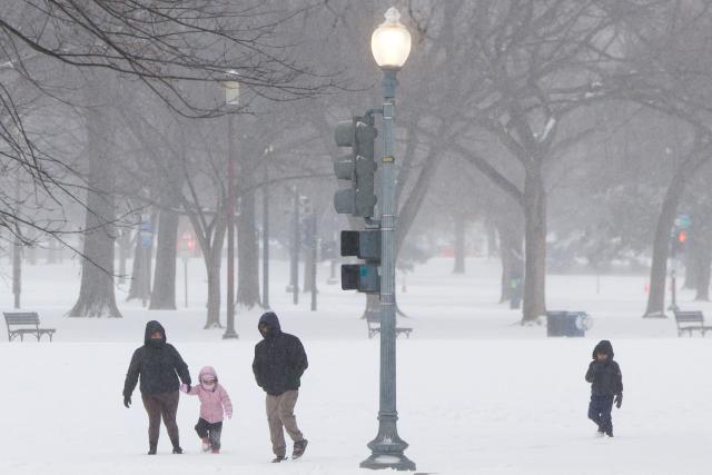 A family walks in the snow near the National Mall in Washington, DC, on January 25, 2026. A massive winter storm on January 24 dumped snow and freezing rain from New Mexico to North Carolina as it swept across the United States towards the northeast, threatening tens of millions of Americans with blackouts, transportation chaos and bone-chilling cold. After battering the country's southwest and central areas, the storm system began to hit the heavily populated mid-Atlantic and northeastern states as a frigid air mass settled in across the nation. (Photo by Amid FARAHI / AFP)