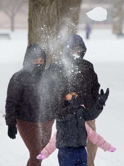 A family walks in the snow near the National Mall in Washington, DC, on January 25, 2026. A massive winter storm on January 24 dumped snow and freezing rain from New Mexico to North Carolina as it swept across the United States towards the northeast, threatening tens of millions of Americans with blackouts, transportation chaos and bone-chilling cold. After battering the country's southwest and central areas, the storm system began to hit the heavily populated mid-Atlantic and northeastern states as a frigid air mass settled in across the nation. (Photo by Amid FARAHI / AFP)