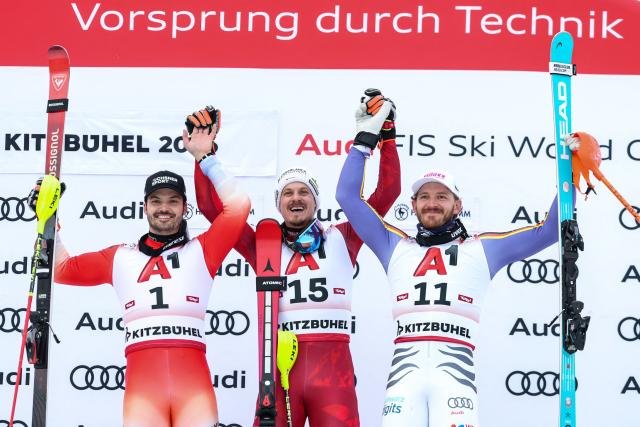 (From L) Second Place Switzerland's Loic Meillard, winner Austria's Manuel Feller and third place Germany's Linus Strasser celebrate on the podium after the Men's slalom event of the FIS Alpine Skiing World Cup in Kitzbuehel, Austria, on January 25, 2026. (Photo by Johann GRODER / APA / AFP) / Austria OUT