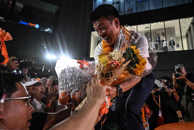 People's Party leader and prime ministerial candidate Natthaphong Ruengpanyawut (C) receives flowers from supporters during a campaign rally ahead of the general election in Bangkok on January 25, 2026. (Photo by Lillian SUWANRUMPHA / AFP)