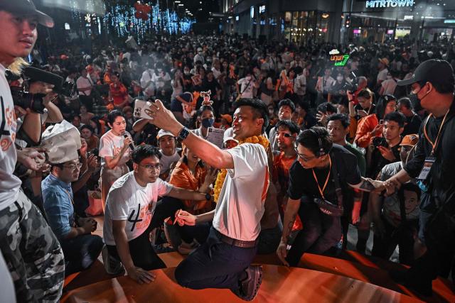 People's Party leader and prime ministerial candidate Natthaphong Ruengpanyawut (C) takes a selfie with supporters during a campaign rally ahead of the general election in Bangkok on January 25, 2026. (Photo by Lillian SUWANRUMPHA / AFP)