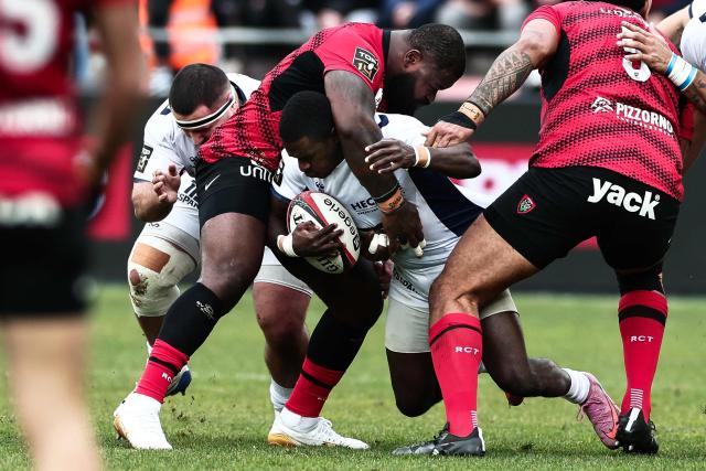 Montpellier’s French wing Gabriel Ngandebe is tackled by Toulon's Cameroonian prop Dany Priso during the French Top 14 rugby union match between Rugby Club Toulonnais (Toulon) and Montpellier Herault Rugby at the Stade Mayol in Toulon, south-eastern France on January 25, 2026. (Photo by Thibaud MORITZ / AFP)