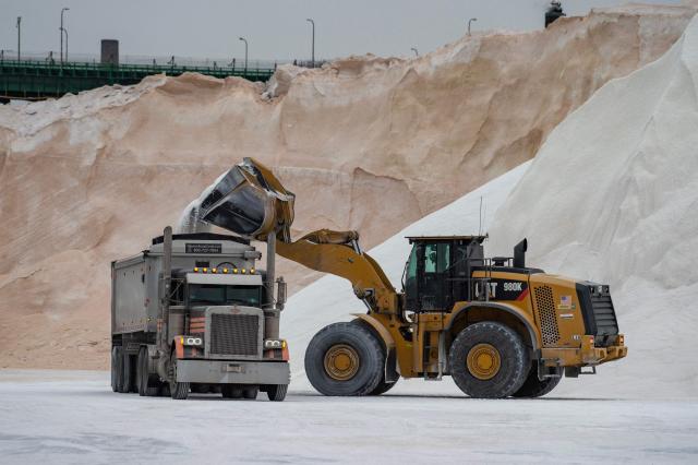 A front end loader fills a trailer with salt from the salt piles at Eastern Salt for use in the upcoming snow storm in Chelsea, Massachusetts on January 25, 2026. A massive winter storm on January 24 dumped snow and freezing rain from New Mexico to North Carolina as it swept across the United States towards the northeast, threatening tens of millions of Americans with blackouts, transportation chaos and bone-chilling cold. After battering the country's southwest and central areas, the storm system began to hit the heavily populated mid-Atlantic and northeastern states as a frigid air mass settled in across the nation. (Photo by Joseph Prezioso / AFP)
