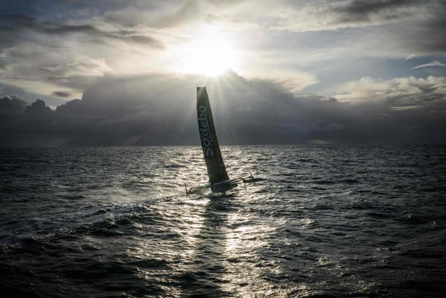 French skipper Thomas Coville and his crew members sail aboard the Ultim class multihull "Sodebo Ultim 3" after crossing the finish line at the end of their Jules Verne Trophy attempt, in the Atlantic Ocean, off the coast of Brest, Brittany, western France, on January 25, 2026. The Jules Verne Trophy is a prize for the fastest crewed, unassisted and non-stop circumnavigation of the world on any type of yacht. (Photo by Loic VENANCE / AFP)