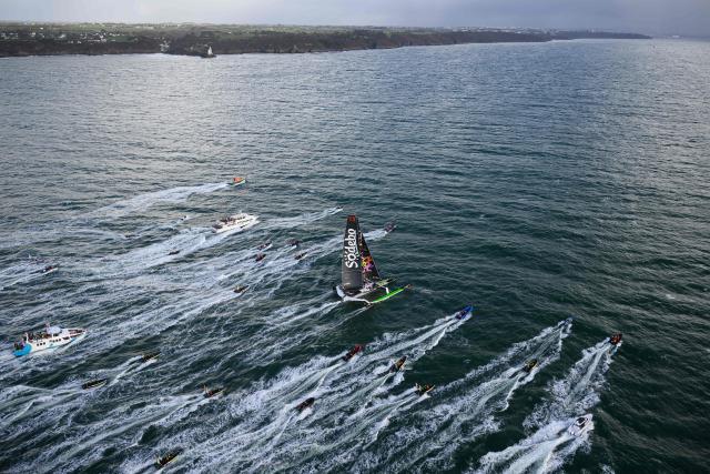 French skipper Thomas Coville and his crew members sail aboard the Ultim class multihull "Sodebo Ultim 3" after crossing the finish line at the end of their Jules Verne Trophy attempt, in the Atlantic Ocean, off the coast of Brest, Brittany, western France, on January 25, 2026. The Jules Verne Trophy is a prize for the fastest crewed, unassisted and non-stop circumnavigation of the world on any type of yacht. (Photo by Loic VENANCE / AFP)