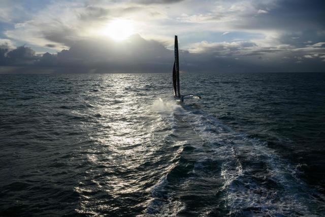 French skipper Thomas Coville and his crew members sail aboard the Ultim class multihull "Sodebo Ultim 3" after crossing the finish line at the end of their Jules Verne Trophy attempt, in the Atlantic Ocean, off the coast of Brest, Brittany, western France, on January 25, 2026. The Jules Verne Trophy is a prize for the fastest crewed, unassisted and non-stop circumnavigation of the world on any type of yacht. (Photo by Loic VENANCE / AFP)