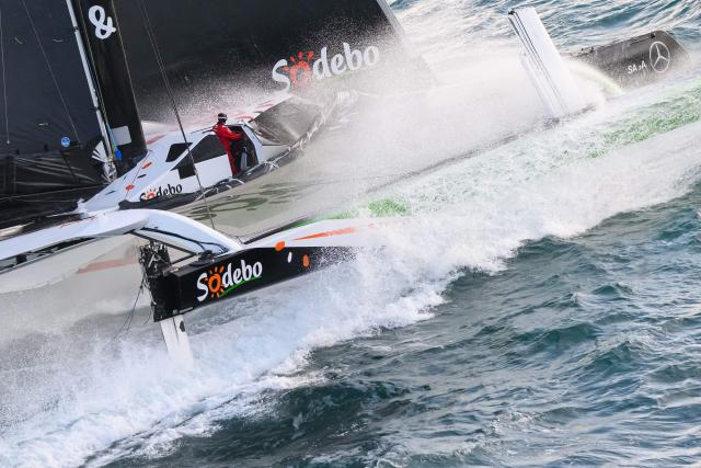 French skipper Thomas Coville and his crew members sail aboard the Ultim class multihull "Sodebo Ultim 3" after crossing the finish line at the end of their Jules Verne Trophy attempt, in the Atlantic Ocean, off the coast of Brest, Brittany, western France, on January 25, 2026. The Jules Verne Trophy is a prize for the fastest crewed, unassisted and non-stop circumnavigation of the world on any type of yacht. (Photo by Loic VENANCE / AFP)