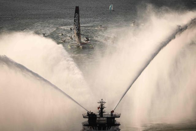French rescue tugboat Abeille Bretagne spray water to welcome French skipper Thomas Coville and his crew members arrival in Brest harbour aboard the Ultim class multihull "Sodebo Ultim 3" after crossing the finish line of their successful attempt of breaking the Jules Verne Trophy record in 40 days 10 hours and 45 minutes, off the coast of Brest, Brittany, on January 25, 2026. The Jules Verne Trophy is a prize for the fastest crewed, unassisted and non-stop circumnavigation of the world on any type of yacht. (Photo by Loic VENANCE / AFP)