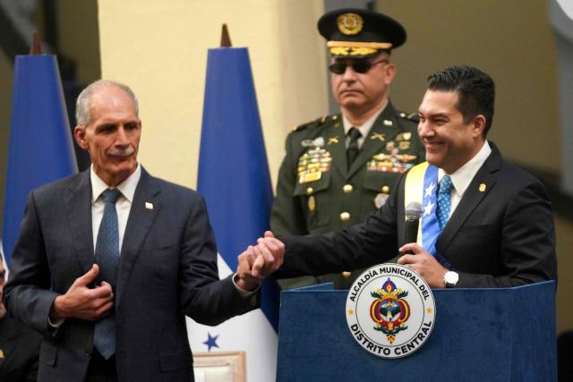 Honduran President-elect Nasry Asfura greets Mayor Juan Diego Zelaya during the inauguration of the National Mayor's Office of the Central District, at the National Museum in Tegucigalpa on January 25, 2026. Earliert this month Honduras electoral authorities rejected an order by the outgoing president to recount November's election won by Trump-backed candidate Nasry Asfura, a conservative businessman who was declared the winner of Honduras's presidential election on December 24, weeks after a tight race marred by delays and allegations of fraud. (Photo by Johny Magallanes / AFP)