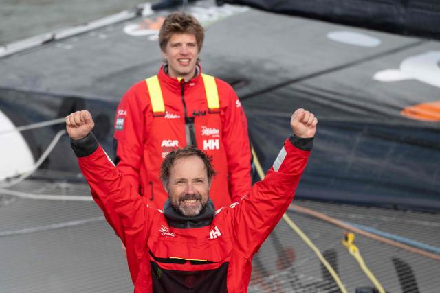 French skipper Thomas Coville (front) and a crew member celebrate as they enter Brest harbour on the Ultim class multihull "Sodebo Ultim 3" after crossing the finish line of their successful attempt of breaking the Jules Verne Trophy record in 40 days 10 hours and 45 minutes, off the coast of Brest, Brittany, on January 25, 2026. The Jules Verne Trophy is a prize for the fastest crewed, unassisted and non-stop circumnavigation of the world on any type of yacht. (Photo by Sebastien Salom-Gomis / AFP)