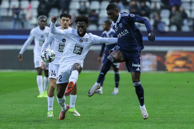 Angers' Haitian defender #02 Carlens Arcus (C) and Paris FC's French forward #07 Alimami Gory  fight for the ball during the French L1 football match between Paris FC and SCO Angers at the Stade Jean-Bouin in Paris on January 25, 2026. (Photo by Thomas SAMSON / AFP)