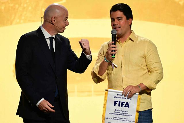 Brazil's Sports Minister Andre Fufuca (R) speaks while presenting FIFA President Gianni Infantino with a commemorative pennant during the 2027 FIFA Women's World Cup launch ceremony in Rio de Janeiro, Brazil on January 25, 2026. (Photo by Pablo PORCIUNCULA / AFP)