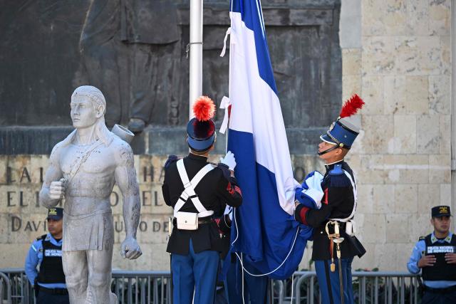 Honduran military cadets hang the national flag prior to the installation of the first legislature outside the Congress in Tegucigalpa on January 25, 2026. Earliert this month Honduras electoral authorities rejected an order by the outgoing president to recount November's election won by Trump-backed candidate Nasry Asfura, a conservative businessman who was declared the winner of Honduras's presidential election on December 24, weeks after a tight race marred by delays and allegations of fraud. (Photo by Johan ORDÓÑEZ / AFP)